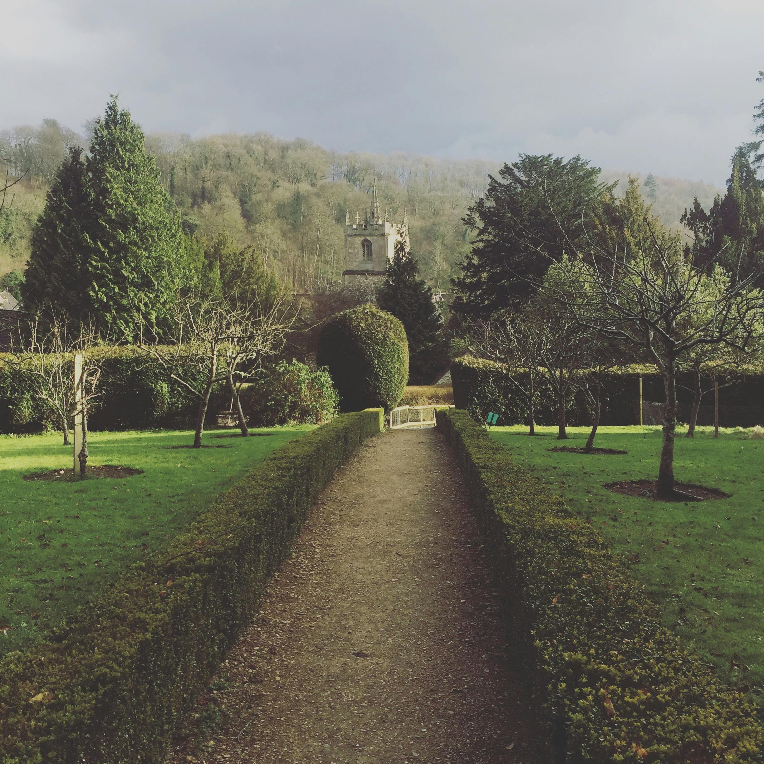 Picturesque garden pathway leading to a church in rural Dumfries and Galloway, Scotland.